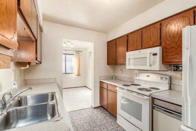 kitchen featuring sink, a textured ceiling, and white appliances