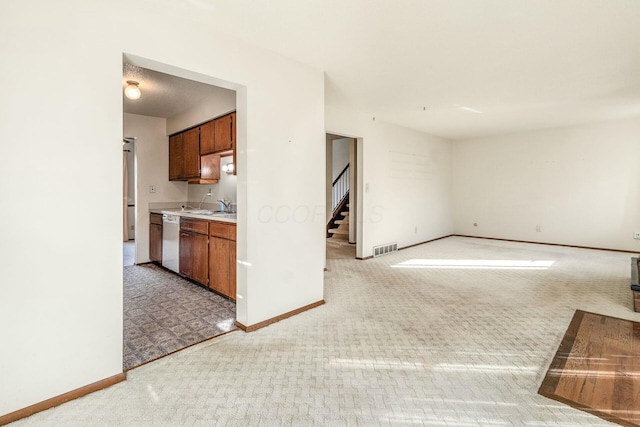 kitchen featuring dishwashing machine, sink, and carpet flooring