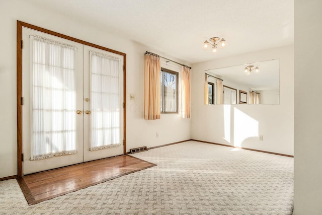 entryway featuring french doors, plenty of natural light, and carpet flooring