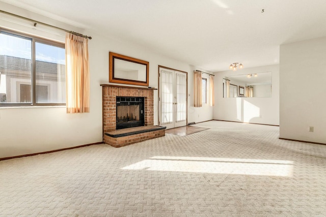 unfurnished living room with light carpet, a fireplace, and french doors