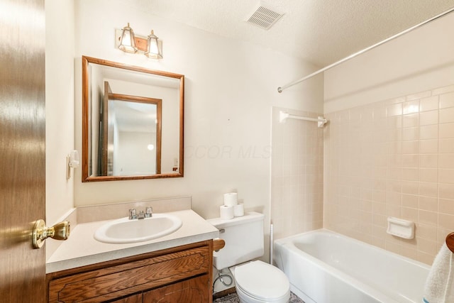 full bathroom featuring vanity, tiled shower / bath, a textured ceiling, and toilet