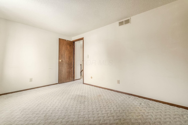 empty room with a textured ceiling and carpet