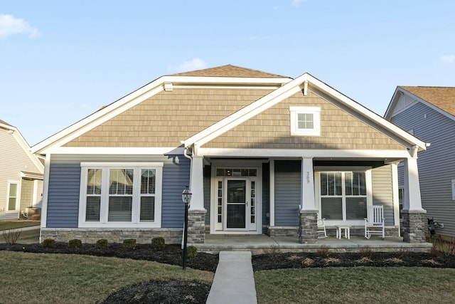 craftsman inspired home with covered porch and a front lawn