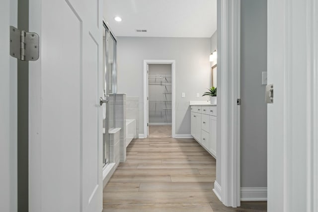 bathroom with vanity, hardwood / wood-style floors, and a shower with shower door