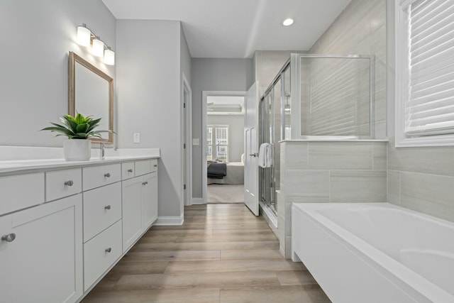 bathroom with vanity, separate shower and tub, and wood-type flooring