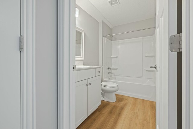 full bathroom featuring hardwood / wood-style flooring, vanity, toilet, and shower / bathing tub combination