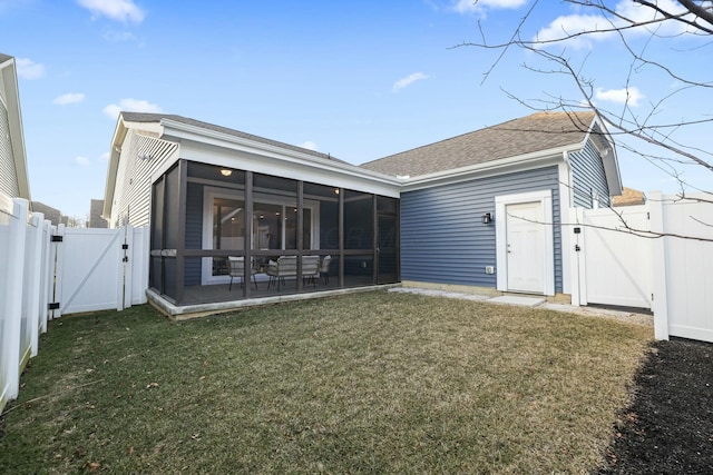 back of property featuring a lawn, a sunroom, and a patio