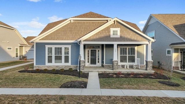 craftsman inspired home with covered porch and a front lawn