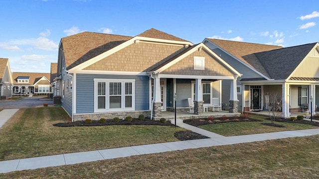 craftsman inspired home with a front lawn and covered porch