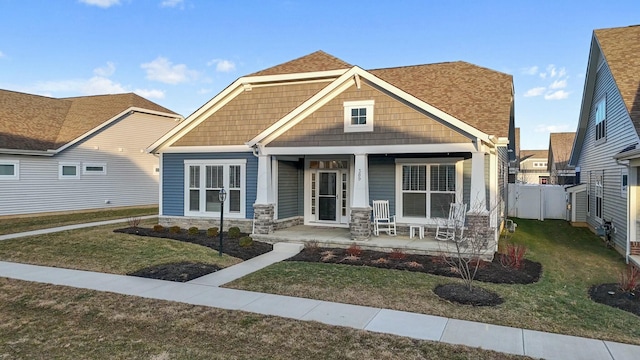 craftsman house featuring covered porch and a front yard