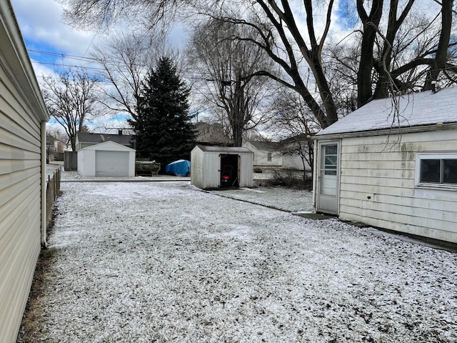 yard covered in snow with a storage unit