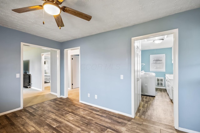 interior space with ceiling fan, separate washer and dryer, dark hardwood / wood-style floors, and a textured ceiling