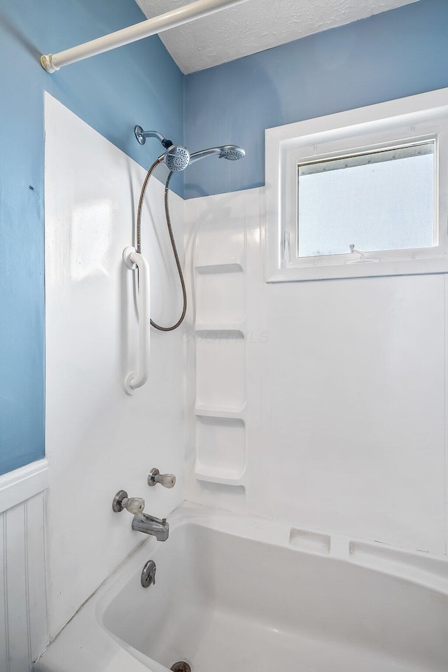 bathroom with shower / washtub combination and a textured ceiling