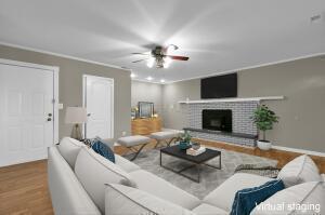 living room with wood-type flooring and crown molding