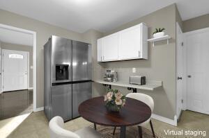 kitchen with white cabinetry and stainless steel refrigerator with ice dispenser