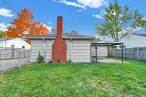 rear view of property featuring a lawn and a patio area