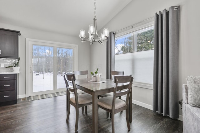 dining room featuring dark hardwood / wood-style flooring, a chandelier, and vaulted ceiling