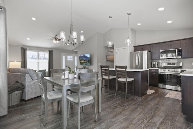 dining area with dark hardwood / wood-style floors, a chandelier, and high vaulted ceiling