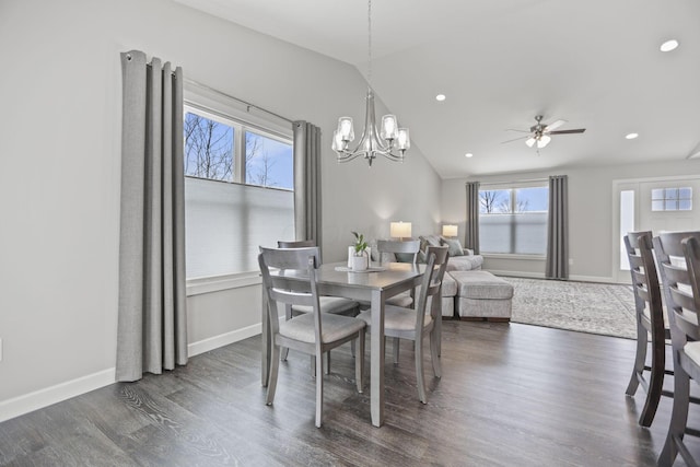 dining space featuring lofted ceiling, ceiling fan with notable chandelier, and dark hardwood / wood-style floors