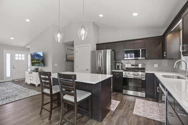 kitchen with pendant lighting, sink, dark hardwood / wood-style flooring, a center island, and stainless steel appliances