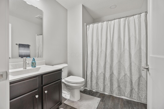 bathroom featuring vanity, a textured ceiling, wood-type flooring, and toilet