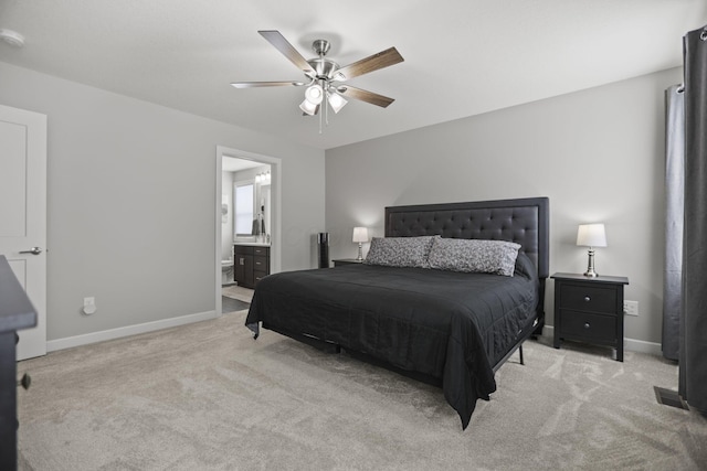 carpeted bedroom with ensuite bath and ceiling fan