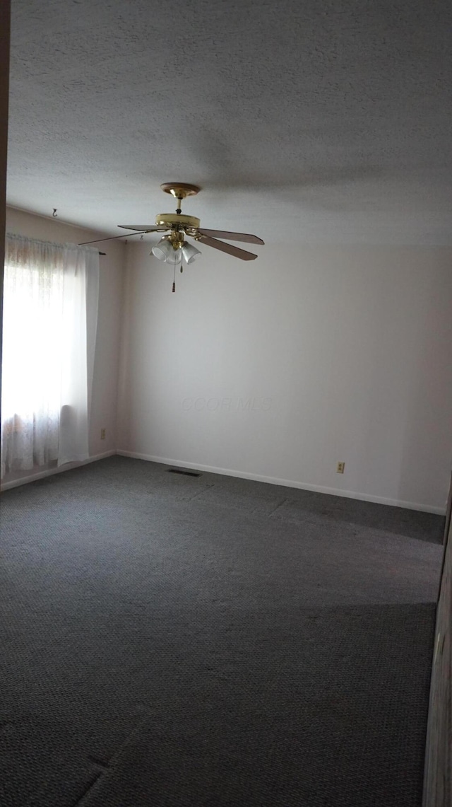 spare room with ceiling fan, carpet flooring, and a textured ceiling