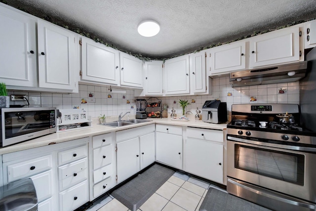 kitchen featuring light tile patterned flooring, sink, white cabinetry, tasteful backsplash, and appliances with stainless steel finishes