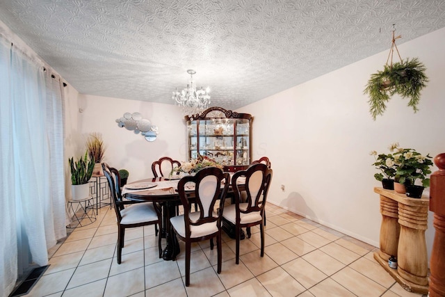 dining room featuring light tile patterned flooring, a textured ceiling, and an inviting chandelier