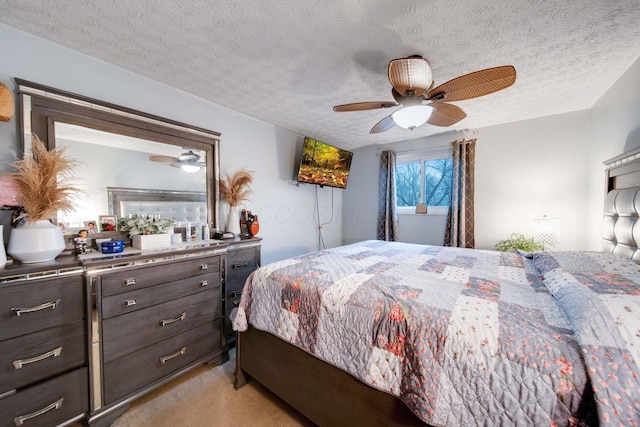 bedroom with ceiling fan, light carpet, and a textured ceiling