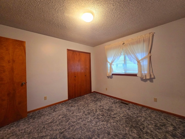 unfurnished bedroom with carpet floors, a closet, and a textured ceiling