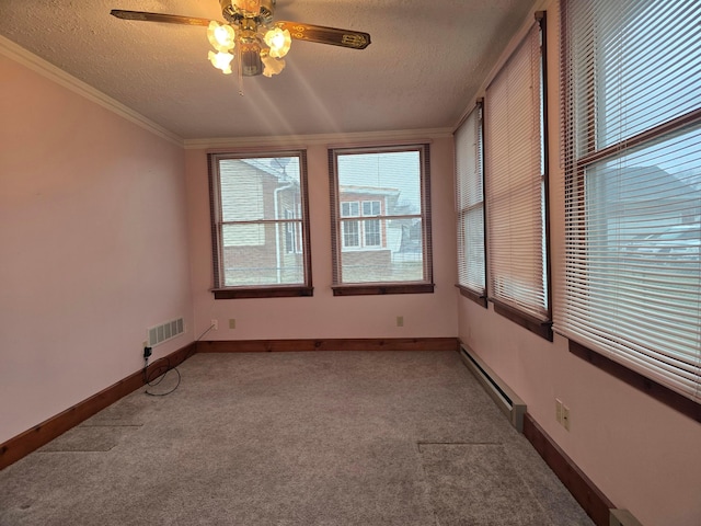 unfurnished room featuring a baseboard radiator, carpet, ceiling fan, crown molding, and a textured ceiling