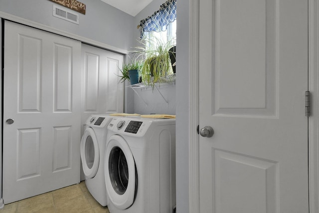 washroom with light tile patterned floors and washing machine and clothes dryer