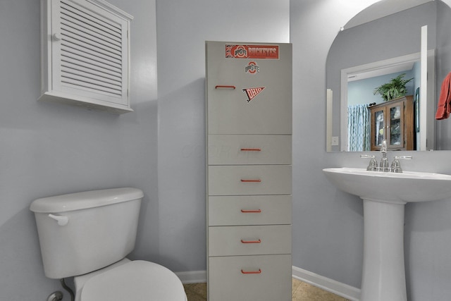 bathroom with toilet and tile patterned flooring