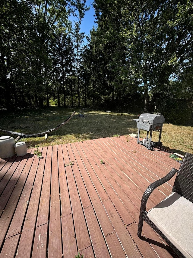 wooden terrace featuring grilling area and a lawn