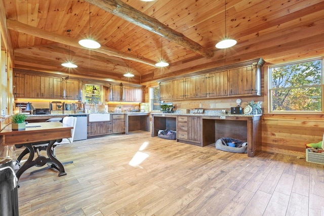 kitchen with pendant lighting, dishwasher, lofted ceiling with beams, and light hardwood / wood-style flooring