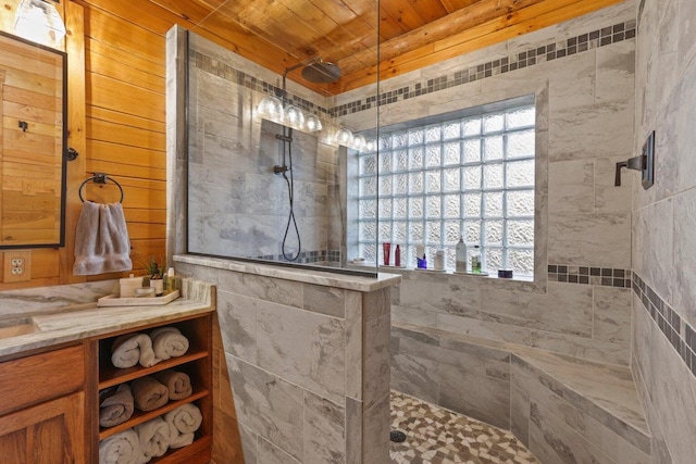 bathroom featuring a healthy amount of sunlight, a tile shower, and wood ceiling