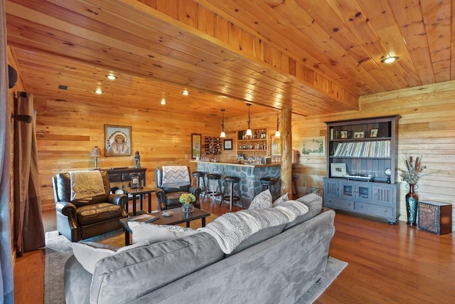 living room featuring wood-type flooring, wooden ceiling, wood walls, and indoor bar