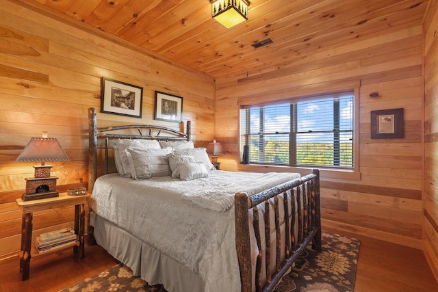 bedroom with hardwood / wood-style flooring, wooden ceiling, and wood walls