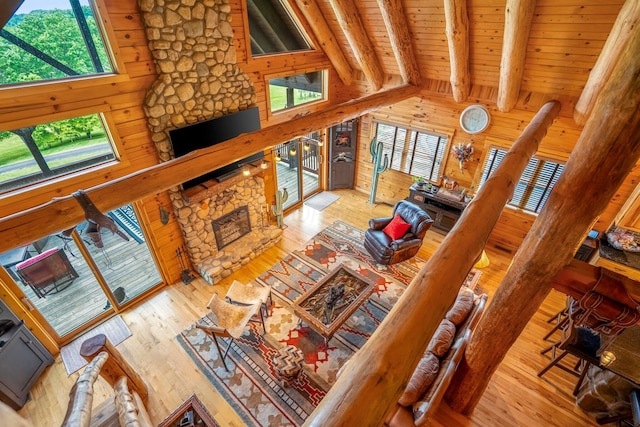20358 Buena Vista Rd, Rockbridge, OH 43149 - living area featuring a fireplace, wooden ceiling with exposed beams, wood walls, hardwood / wood-style floors, and high vaulted ceiling