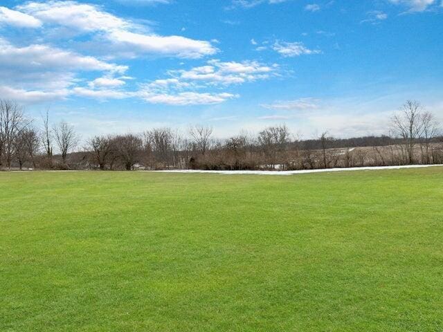 view of property's community featuring a rural view and a lawn