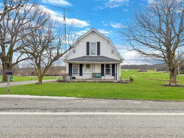 farmhouse-style home featuring a front lawn and a porch