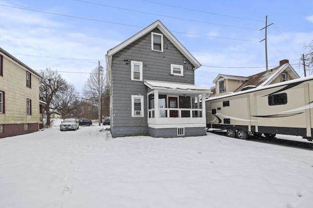 snow covered property featuring a sunroom