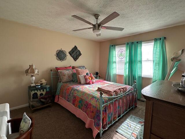 carpeted bedroom featuring a textured ceiling and ceiling fan