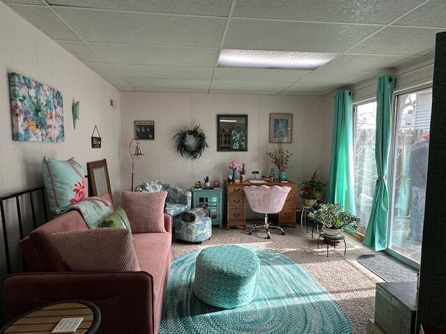 interior space with carpet floors and a paneled ceiling