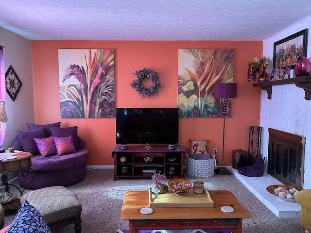 carpeted living room featuring a textured ceiling and a fireplace