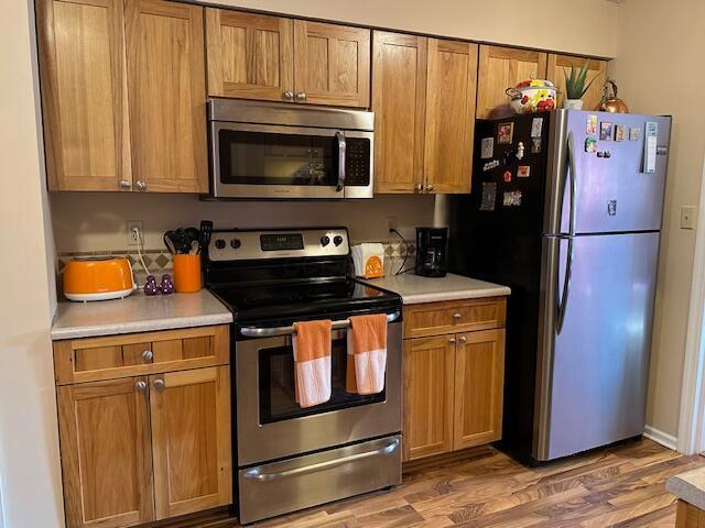 kitchen with stainless steel appliances and dark hardwood / wood-style flooring