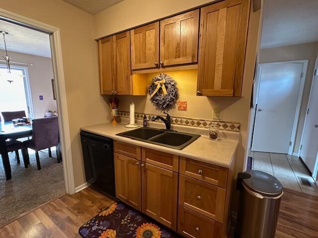 kitchen featuring dark hardwood / wood-style flooring, sink, and dishwasher