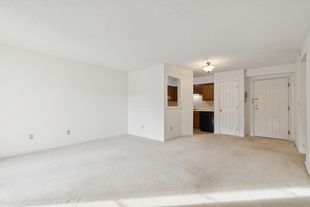 unfurnished living room featuring light carpet and a textured ceiling