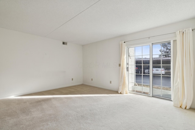 carpeted spare room with a textured ceiling